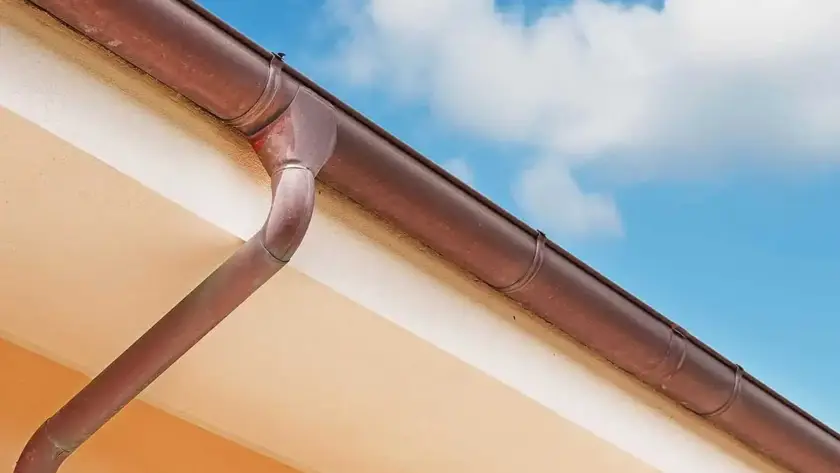 Pluviale in acciaio lungo il tetto di un abitazione.