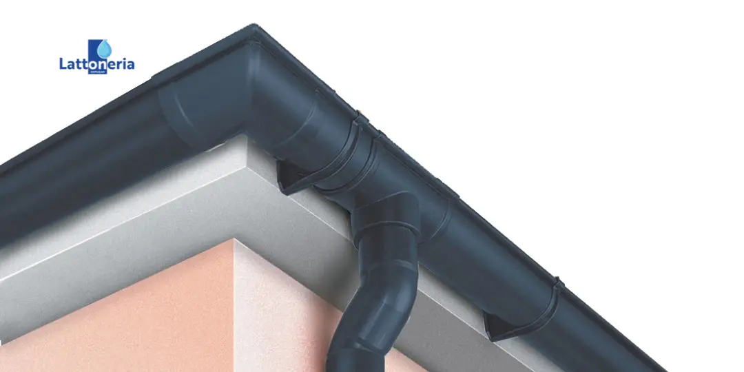 Grondaia e pluviale in metallo installati su spigolo di tetto, sistema di raccolta e smaltimento dell’acqua piovana.