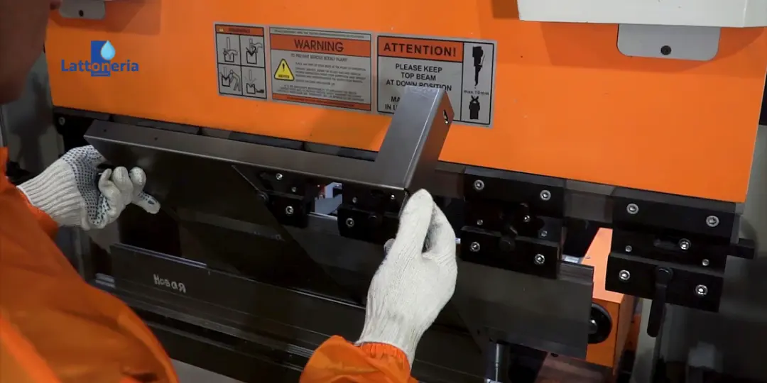 Operatore Lattoneria Cotugno mentre piega un profilo in lamiera con pressopiega in officina