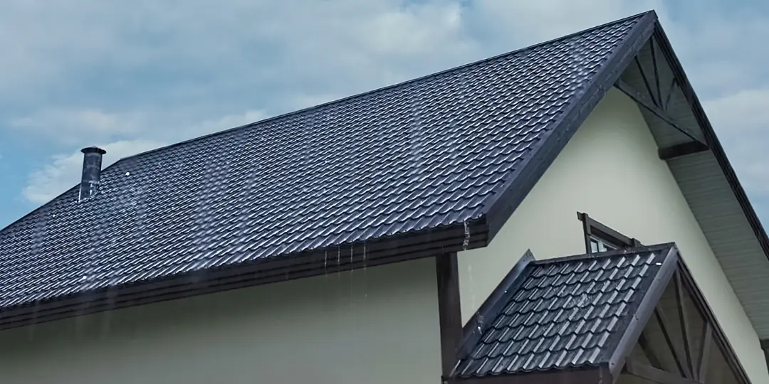 Tetto a falde con copertura in tegole e acqua piovana che scorre lungo la gronda